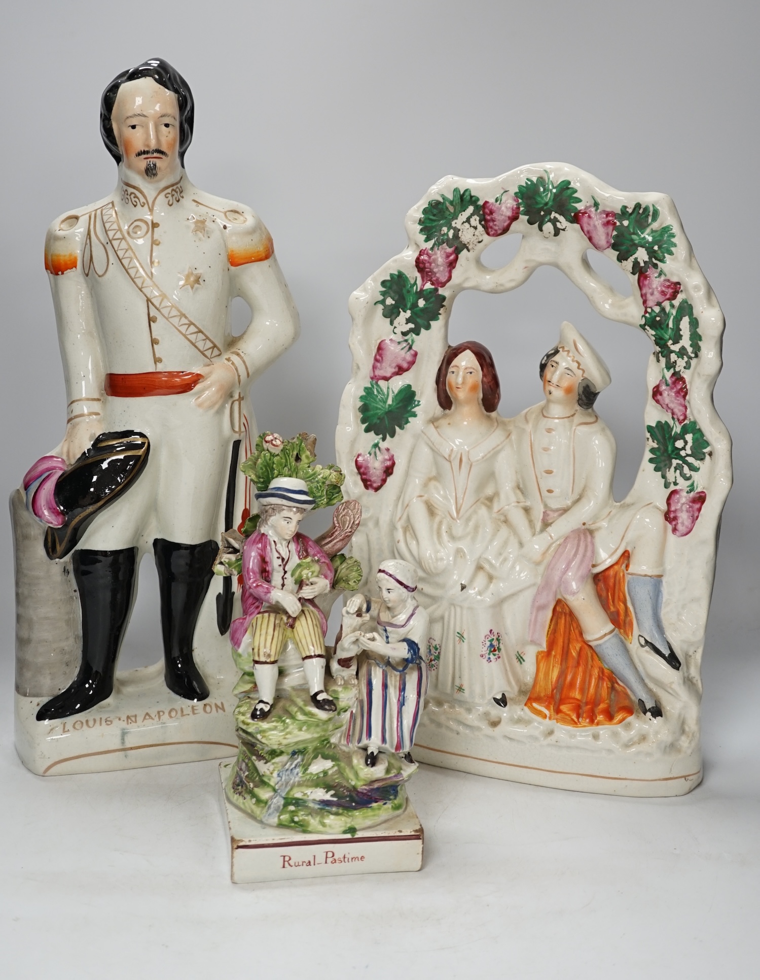 A group of three Staffordshire figures, to include a figure of Louis Napoleon, 'Rural Pastime', the cobbler and wife, tallest 41.5cm. Condition - fair